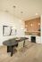 Elegant dining area with contemporary art, stylish pendant lights, and a sleek mini bar, perfect for entertaining.