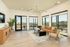Bright, modern living room with stylish decor, expansive windows, and scenic balcony views.