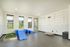 Inviting pet-friendly indoor play area with vibrant blue agility equipment, ample sunlight, and creative wall decor, perfect for active pets.