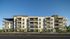 Modern apartment building showcasing stylish balconies, lush landscaping, and a contemporary design under a clear blue sky.