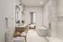 Luxurious bathroom with elegant marble accents, spacious freestanding tub, and double vanity, connecting to a cozy bedroom with picturesque window views.