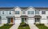 Charming townhouse row with lush greenery, modern design, and inviting, colorful doors.