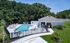 Charming community pool area with modern lounge chairs, lush greenery, and a stylish cabana offering relaxation and leisure.