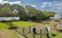 Charming community dog park with shaded benches, green grass, and lush trees in the background.
