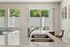 Bright and modern kitchen with sleek granite countertops, a stainless steel sink, and an inviting view of lush greenery through sliding glass doors.