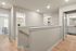 Modern hallway with gleaming hardwood floors leading to a cozy living area, bright bathroom, and elegant closet space.