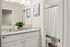 Elegant bathroom with dual sinks, granite countertops, and modern decor, featuring natural light and stylish framed art.