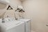 Modern laundry room featuring an efficient washer and dryer set with a convenient overhead shelf for storage.