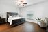 Charming bedroom with elegant dark wood furnishings, cozy bed, and warm natural lighting through blinds.