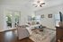 Bright and inviting living room with cozy seating, elegant decor, and abundant natural light from large windows and glass doors.