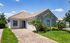 Charming single-story home with a tile roof, stone accents, and lush landscaping in a serene neighborhood.