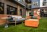 Chic outdoor lounge space with modern seating, vibrant orange accents, and lush greenery at Eastside Heights apartments.