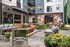 Chic apartment courtyard with stylish seating, lush greenery, and string lighting, offering a perfect outdoor retreat.