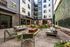 Chic outdoor courtyard with stylish patio furniture and modern design in a vibrant urban apartment complex.