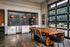 Stunning modern dining area with a rustic wooden table, chic pendant lighting, and spacious glass doors opening to a lush outdoor view.