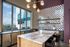 Modern kitchen with chic checkered tile wall, marble island, and large city-view windows, perfect for entertaining.