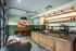 Modern and inviting apartment kitchen with sleek countertops, stylish pendant lighting, and cozy dining area with vibrant artwork.