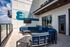 Modern rooftop terrace at Eastside Heights featuring stylish blue seating, a wall-mounted TV, and scenic views.