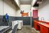 Chic pet spa with modern facilities, featuring a stylish dog wash station, vibrant orange cabinetry, and playful dog mural.