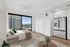 Modern apartment with a cozy bedroom featuring a lush green view, sleek stainless steel fridge, and elegant decor.