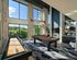 Luxurious recreation room featuring a sleek billiards table, modern decor, and expansive windows offering lush outdoor views.