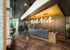 Modern lobby with chic lighting, stylish reception desk, and spacious layout featuring rustic brick walls and vibrant plants.