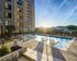Luxurious apartment complex with a stunning rooftop pool, sun loungers, and beautiful sunrise views.