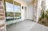 Charming apartment patio with stylish mint green bistro set and serene garden view, perfect for relaxation.