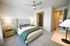 Elegant bedroom with a plush bed, stylish decor, and ample natural light for a serene living experience.