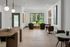 Elegant open-concept interior showcasing modern furnishings, chic artwork, and lush garden views, perfect for stylish living.