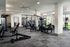 Modern apartment gym equipped with state-of-the-art fitness machines and bright natural lighting for an invigorating workout experience.