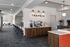Sleek and modern communal area featuring a coffee station with wooden cabinetry and stylish lighting, perfect for socializing or relaxing.