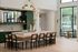 Elegant open-concept kitchen with a luxurious island, stylish green cabinetry, and large windows offering abundant natural light.
