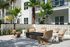 Charming outdoor seating area with stylish wicker chairs, modern fire pit, and lush greenery, creating a cozy and inviting atmosphere.