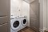 Modern laundry room featuring energy-efficient washer and dryer, highlighted by sleek shelving and elegant flooring.