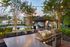 Charming outdoor space featuring a sparkling pool, elegant string lights, and modern BBQ grills, perfect for relaxed gatherings.