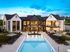 Stunning luxury apartment complex featuring a modern design with expansive windows, a pristine swimming pool, and inviting outdoor lounge areas.