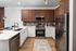 Modern kitchen with sleek stainless steel appliances, elegant wood cabinets, and a stylish white countertop, creating a warm and inviting ambiance.