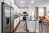 Modern kitchen with sleek stainless steel appliances, stylish breakfast bar, and cozy living area with plush seating.
