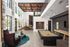 Luxurious modern clubhouse featuring high ceilings, a stylish billiards table, plush seating, and expansive windows allowing natural light.