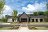 Charming modern office building with elegant architecture, set against a backdrop of lush greenery and a bright blue sky.