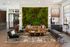 Elegant apartment lobby with a lush vertical garden, stylish seating, and modern decor, exuding a warm and inviting atmosphere.