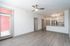 Bright and modern apartment with open-plan kitchen, sleek ceiling fan, and elegant light-colored flooring.