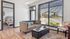 Bright and inviting living room with modern sofa, expansive window views, and cozy adjoining bedroom, perfect for relaxation.