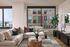 Chic urban living room with elegant decor, large windows offering stunning city views, and a cozy L-shaped sofa complemented by stylish accents.