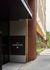 Elegant modern building entrance of The Juniper, featuring sleek architectural design and lush greenery along the walkway.