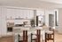 Modern kitchen with sleek white cabinetry, stainless steel appliances, and a chic breakfast bar with stylish seating.