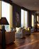 Elegant lounge area with large windows offering panoramic views, stylish armchairs, and modern art decor under warm ambient lighting.