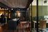 Modern office space with sleek black pendant lights, wood flooring, and glass partitioned areas for privacy and productivity.