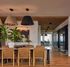 Elegant dining area with leather chairs, modern pendant lights, and an artistic interior design, creating a warm and inviting atmosphere.